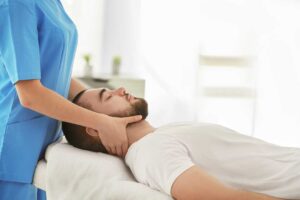 Pregnant woman comfortably lying on her side as a chiropractor adjusts her back in a clinic setting.