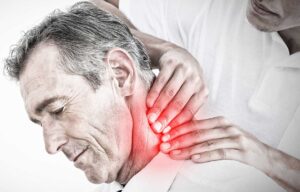 A professional chiropractor showing a spine model to an adult patient in a calm, warmly lit clinic room.