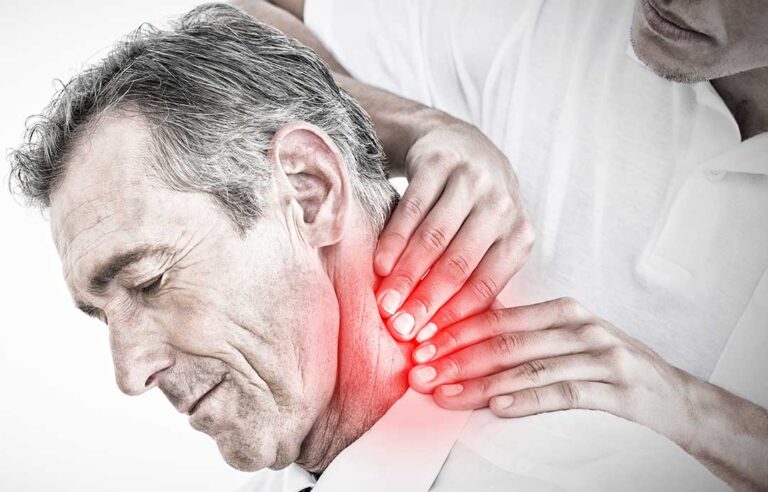 A professional chiropractor showing a spine model to an adult patient in a calm, warmly lit clinic room.